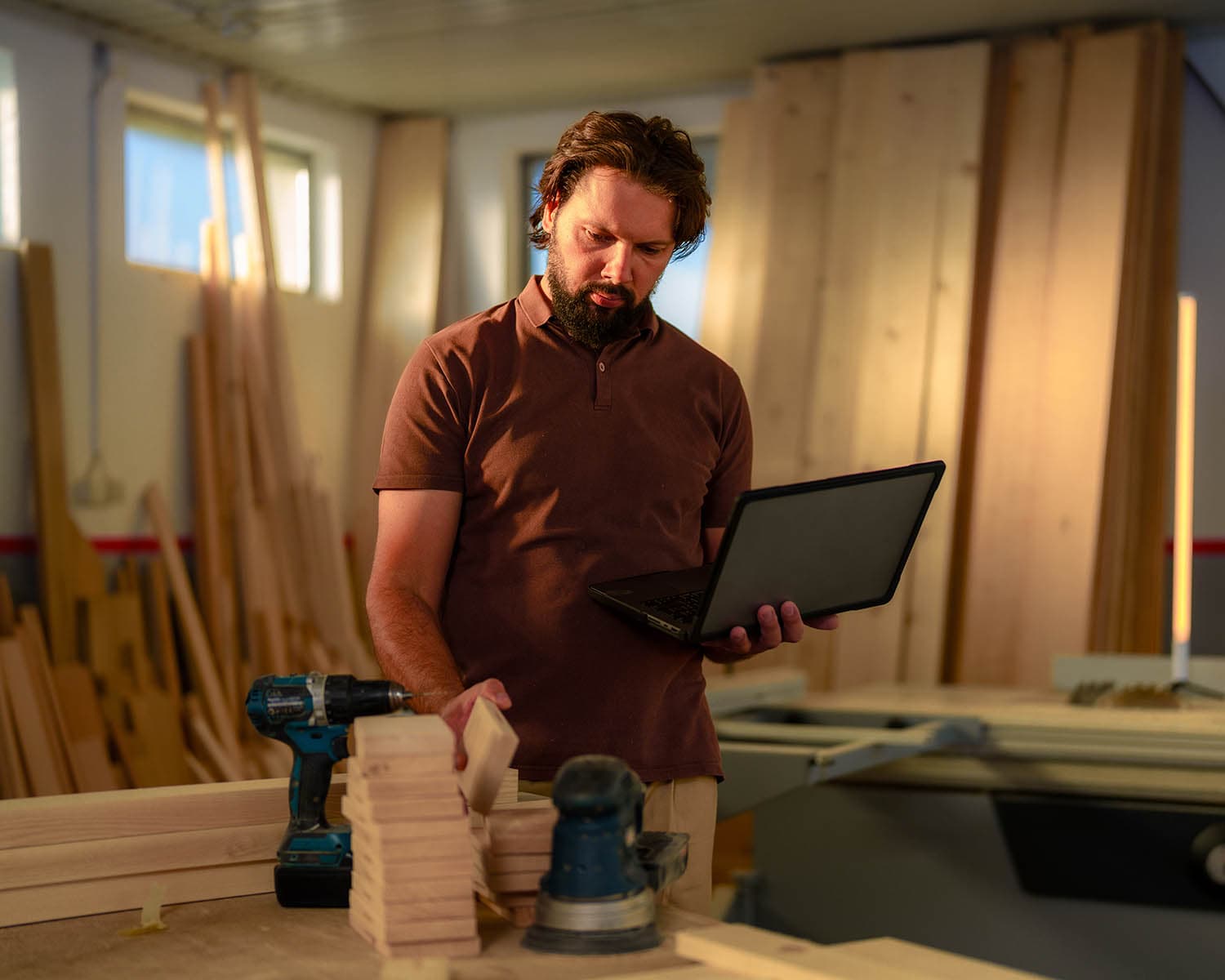 Artisan d’un commerce local utilisant un ordinateur portable dans son atelier